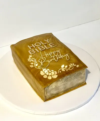 Cake sculpted as a gold book with stenciled flowers, Happy Birthday lettering and painted page edges.