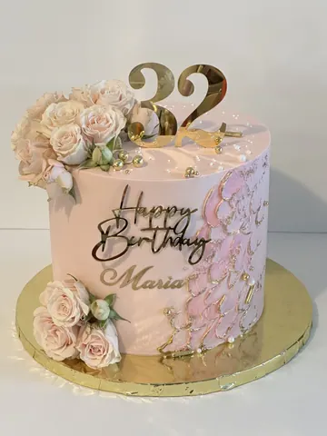 Blush pink cake with cream and pink roses, piped lace details, a gold 32 topper and a gold Happy Birthday sign.