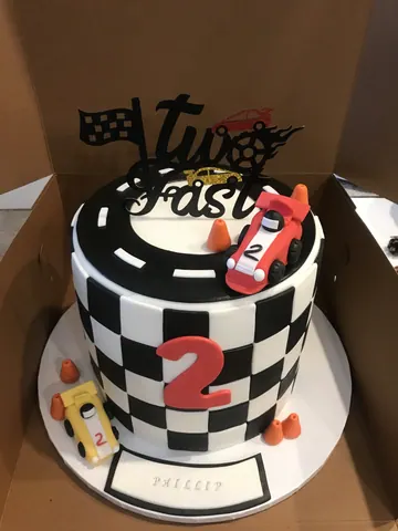 Black and white checkered cake with a road, a red race car, a red number 2 and a Two Fast topper.
